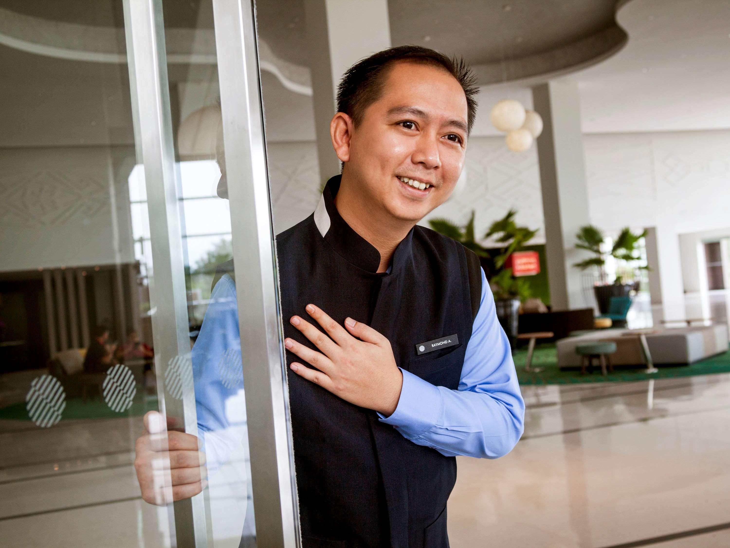 Hotel Pullman Miri Waterfront Esterno foto A doorman at a hotel in Vietnam